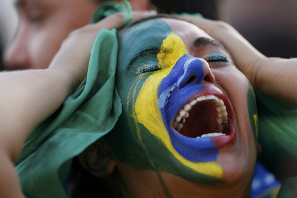 Fans of Brazil react while watching a broadcast of the 2014 World Cup semi-final against Germany at the Fan Fest in Brasilia