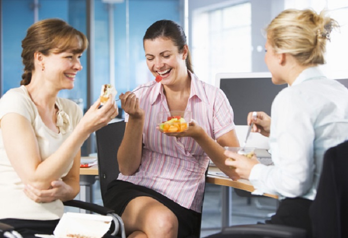 Coworkers eating in office