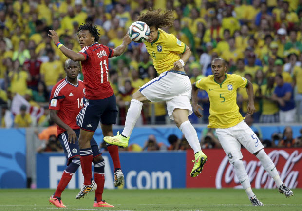 Brazil's David Luiz head the ball next to Colombia's Juan Cuadrado during the World Cup quarterfinal soccer match between Brazil and Colombia at the Arena Castelao in Fortaleza, Brazil, Friday, July 4, 2014. (AP Photo/Hassan Ammar)